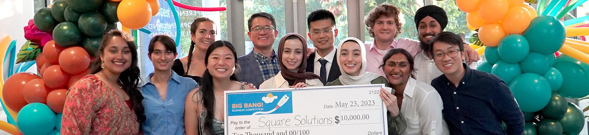 photo of a group of students holding a large check